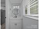 Modern bathroom with white vanity, round mirror, and natural light at 10405 Club Car Ct, Mint Hill, NC 28227