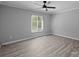 A bright bedroom with a modern ceiling fan and window with natural light on gray walls at 10405 Club Car Ct, Mint Hill, NC 28227