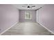 Spacious bedroom featuring light purple walls, light colored wood floors, and bright window at 10405 Club Car Ct, Mint Hill, NC 28227