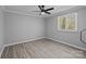 Empty bedroom with light gray walls, ceiling fan, LVP flooring, and natural light at 10405 Club Car Ct, Mint Hill, NC 28227