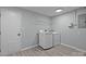 Bright laundry room with modern washer and dryer, shelving, and light gray walls at 10405 Club Car Ct, Mint Hill, NC 28227