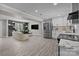 Open-concept living room with wood floors, built-in shelves, and stainless steel appliances at 10405 Club Car Ct, Mint Hill, NC 28227