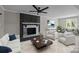Cozy living room with a brick fireplace, modern furniture, and a ceiling fan at 10405 Club Car Ct, Mint Hill, NC 28227