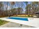 A backyard pool surrounded by a spacious concrete deck and grassy area at 10405 Club Car Ct, Mint Hill, NC 28227