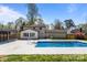 Backyard featuring a pool, grass, and a two-story home on a sunny day at 10405 Club Car Ct, Mint Hill, NC 28227