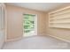 Well-lit, carpeted bedroom showcases built-in shelving, a closet, and a large window at 109 Joe Teague Rd, Hickory, NC 28601