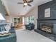Open-concept living room with a painted brick fireplace, ceiling fan, and hardwood floors at 109 Joe Teague Rd, Hickory, NC 28601