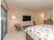Carpeted bedroom with floral bedding, a sliding glass door, a mounted TV, and natural light at 109 Joe Teague Rd, Hickory, NC 28601