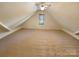 Finished attic space with carpet flooring, slanted ceilings, and natural light at 10940 Wild Dove Ln, Charlotte, NC 28277