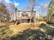 Exterior view of home featuring a spacious yard and stairs leading up to screened in patio at 10940 Wild Dove Ln, Charlotte, NC 28277