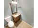 Compact bathroom with toilet, sink, wood vanity, tile floor, and bronze decorative mirror at 10940 Wild Dove Ln, Charlotte, NC 28277