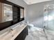 Modern bathroom featuring a double sink vanity, sleek black cabinetry, and a glass-enclosed shower at 10940 Wild Dove Ln, Charlotte, NC 28277