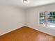 Cozy bedroom featuring wood flooring, a neutral color scheme, and a large window at 10940 Wild Dove Ln, Charlotte, NC 28277