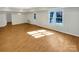 Bright living room with wood flooring, large windows offering ample natural light, and an exterior door at 10940 Wild Dove Ln, Charlotte, NC 28277