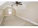 Spacious room under an angled ceiling, featuring a ceiling fan and window, offering ample space at 1125 Bugle Ln, Newton, NC 28658