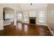 Bright living room boasts hardwood floors, fireplace, neutral walls, and arched doorway for open feel at 1125 Bugle Ln, Newton, NC 28658