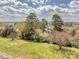 Scenic backyard featuring lush lawn, mature trees, and distant water views enhancing property appeal at 114 Joe Teague Rd, Hickory, NC 28601