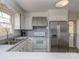 Well-lit kitchen with stainless steel refrigerator and white cabinetry and access to screened porch at 114 Joe Teague Rd, Hickory, NC 28601