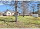 Lush backyard showing the home, trees, and a storage shed, perfect for outdoor enjoyment at 1229 Kent Dr, Lancaster, SC 29720