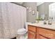 Bathroom features a toilet, tub with shower, vanity and sink, framed art, and foliage at 1229 Kent Dr, Lancaster, SC 29720