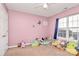 Pink bedroom featuring lots of toys, plushies, a window, and a ceiling fan at 1229 Kent Dr, Lancaster, SC 29720