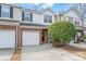 Charming two-story brick townhome featuring an attached garage and front yard landscaping with a mature shrub at 130 Clydesdale Ct, Matthews, NC 28104