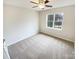 Bedroom featuring neutral carpet, paint, and a ceiling fan along with a window that offers views of the outdoors at 1400 Wessex Ct, Monroe, NC 28110