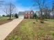 Charming two-story brick home with a red door, black shutters, and a spacious front yard at 1400 Wessex Ct, Monroe, NC 28110