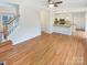 Open-concept living space with hardwood floors, view of the kitchen, and staircase at 1400 Wessex Ct, Monroe, NC 28110