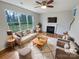 Bright living room featuring a cozy fireplace, large windows, and stylish furnishings at 1400 Wessex Ct, Monroe, NC 28110