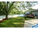 Landscaped backyard with privacy fence, patio, deck, and large shade tree at 142 Wilson Ne St, Concord, NC 28025