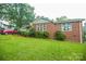 Side view of a brick home highlighting its large, well-maintained lawn and partial view of the attached garage at 142 Wilson Ne St, Concord, NC 28025