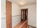 Upstairs hallway with hardwood floors, wooden railing, and built-in storage at 142 Wilson Ne St, Concord, NC 28025
