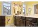 Bathroom with yellow walls featuring a dark vanity, mirror, and window at 147 Belfry Loop, Mooresville, NC 28117