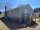 View of home with gray siding, a brick chimney, wooden deck with stairs, and a partial basement at 188 13Th Se St, Hickory, NC 28602
