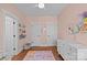 Bedroom features hardwood floors, pastel pink walls, changing table, and two closets at 2212 Yadkin Ave, Charlotte, NC 28205