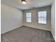 Carpeted bedroom with two windows providing ample natural light at 242 Elrosa Rd, Mooresville, NC 28115