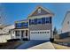 Charming two-story home featuring gray siding, black shutters, a covered porch, and a two-car garage at 242 Elrosa Rd, Mooresville, NC 28115