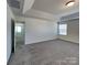 Comfortable main bedroom featuring plush carpet, a tray ceiling, and plenty of natural light at 242 Elrosa Rd, Mooresville, NC 28115