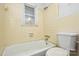 Bathroom includes tiled tub, toilet, and window, ready for renovation to create a serene space at 2519 Arnold Dr, Monroe, NC 28110