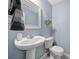Powder room featuring blue walls, a pedestal sink, toilet and an accent mirror at 257 Notable Ln, Rock Hill, SC 29732