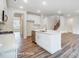 Kitchen island with stainless steel sink, white cabinets and a view of the staircase at 2783 Ashton Park Ln # 67, Monroe, NC 28110