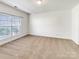 Bright, carpeted bedroom featuring a large window with blinds and neutral walls, ready for personalization at 2924 Zion Renaissance Ln, Charlotte, NC 28269
