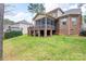 Exterior view of home showcasing the brick facade, screened porch, and spacious backyard with lush lawn at 303 Ridge Reserve Dr # 29, Clover, SC 29710