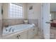 Relaxing bathroom featuring a soaking tub with tile surround and natural light from the frosted glass window at 303 Ridge Reserve Dr # 29, Clover, SC 29710