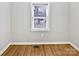 Empty bedroom with hardwood floors, neutral walls, trim, and a window with a view of the outdoors at 325 Oregon St, Charlotte, NC 28208
