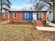 Charming single-story home featuring a brick facade, blue accent paneling, and a welcoming front entrance at 325 Oregon St, Charlotte, NC 28208