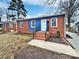 Charming single-story home featuring a brick facade, blue accent paneling, and a welcoming front entrance at 325 Oregon St, Charlotte, NC 28208