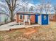 Backyard view of a quaint home with blue accent, a small deck, and a traditional brick facade at 325 Oregon St, Charlotte, NC 28208