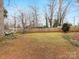 Large backyard featuring a tall wooden fence and a mature tree with a hammock at 3350 Bonneville Dr, Charlotte, NC 28205